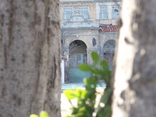 An arched bridge connects the hotel to its outdoor swimming pool.