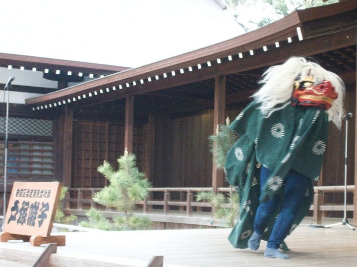 During a lion dance celebration, a Japanese feline races on two feet while chasing away evil and bringing good luck to the visitors of Yasukuni Shrine, Tokyo, Japan. Lion dances occur at times of new beginnings.