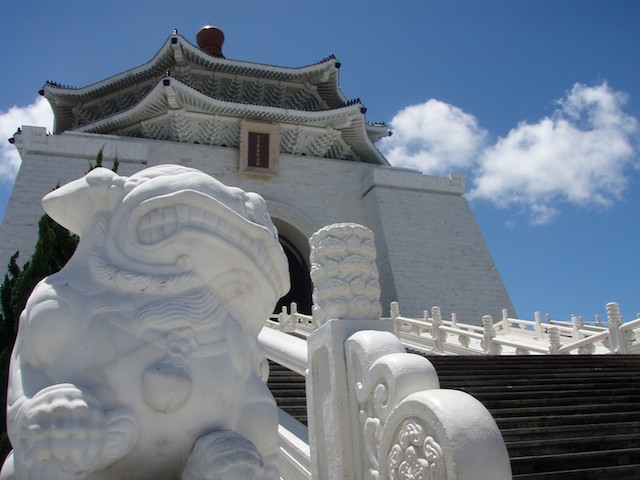 A memorial honors Chiang Kai-Shek. A playful lion guards the memorial.
