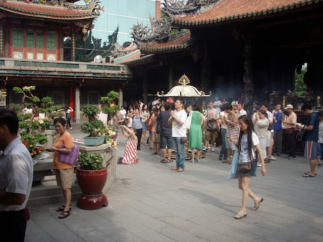 Worshippers pray at Lungshan Temple in Taipai Taiwan. Visiting the temple is a sign of respect for ancestors and idols. Worshippers seeks aid from these during times of stress. They also give thanks.