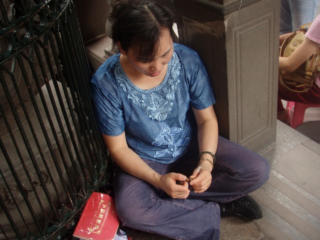 Worshipers recite prayers with bead chains.