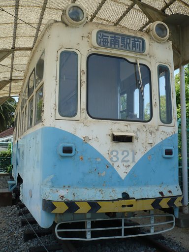 A blue and white street care, known in Japan as a city train.