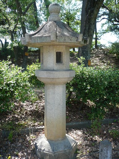 An octoganal stone lantern sits atop an pedestal .