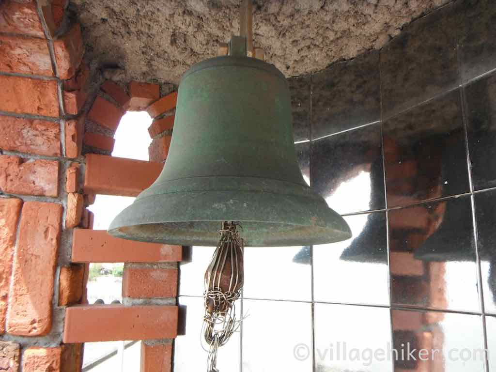 A close up of the bell and its clapper, all reflected in mirrored class inside the Dream Bell.