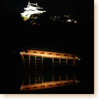 Ohashi Roka and the white castle lighted at night reflected in the moat.