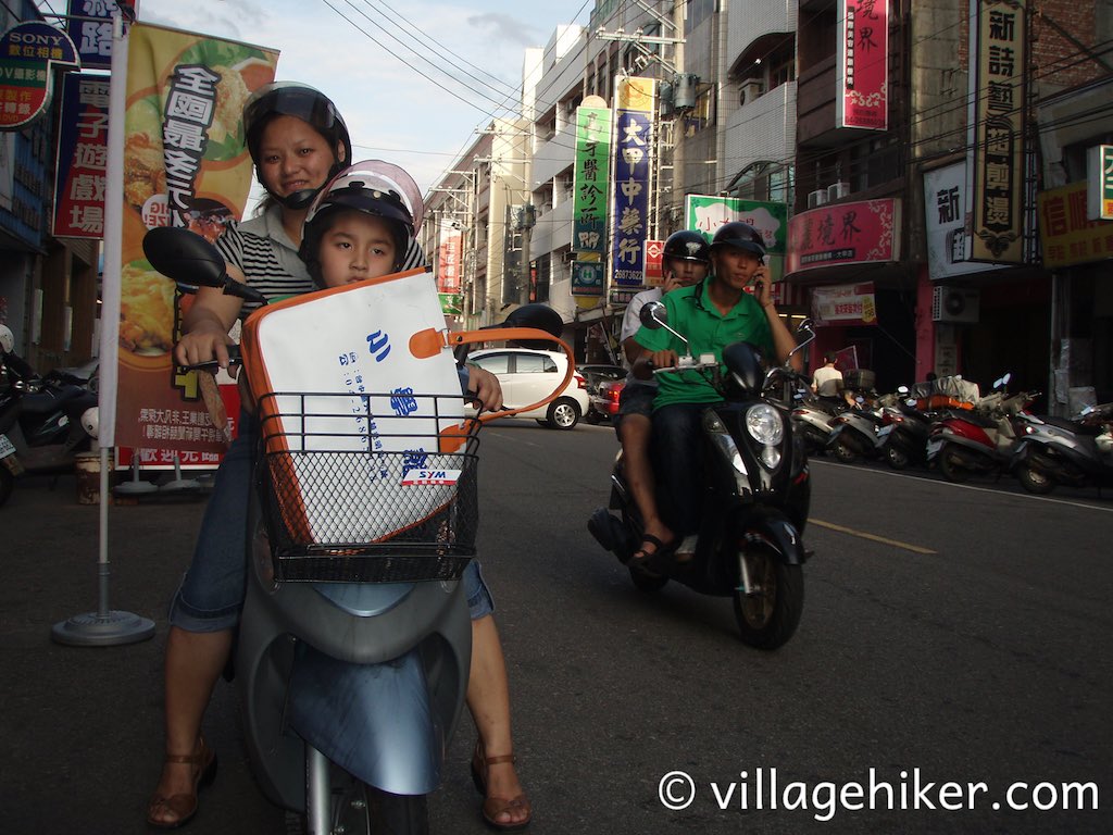 Mom and son get ready to head out, while two cellphone chatters zip by